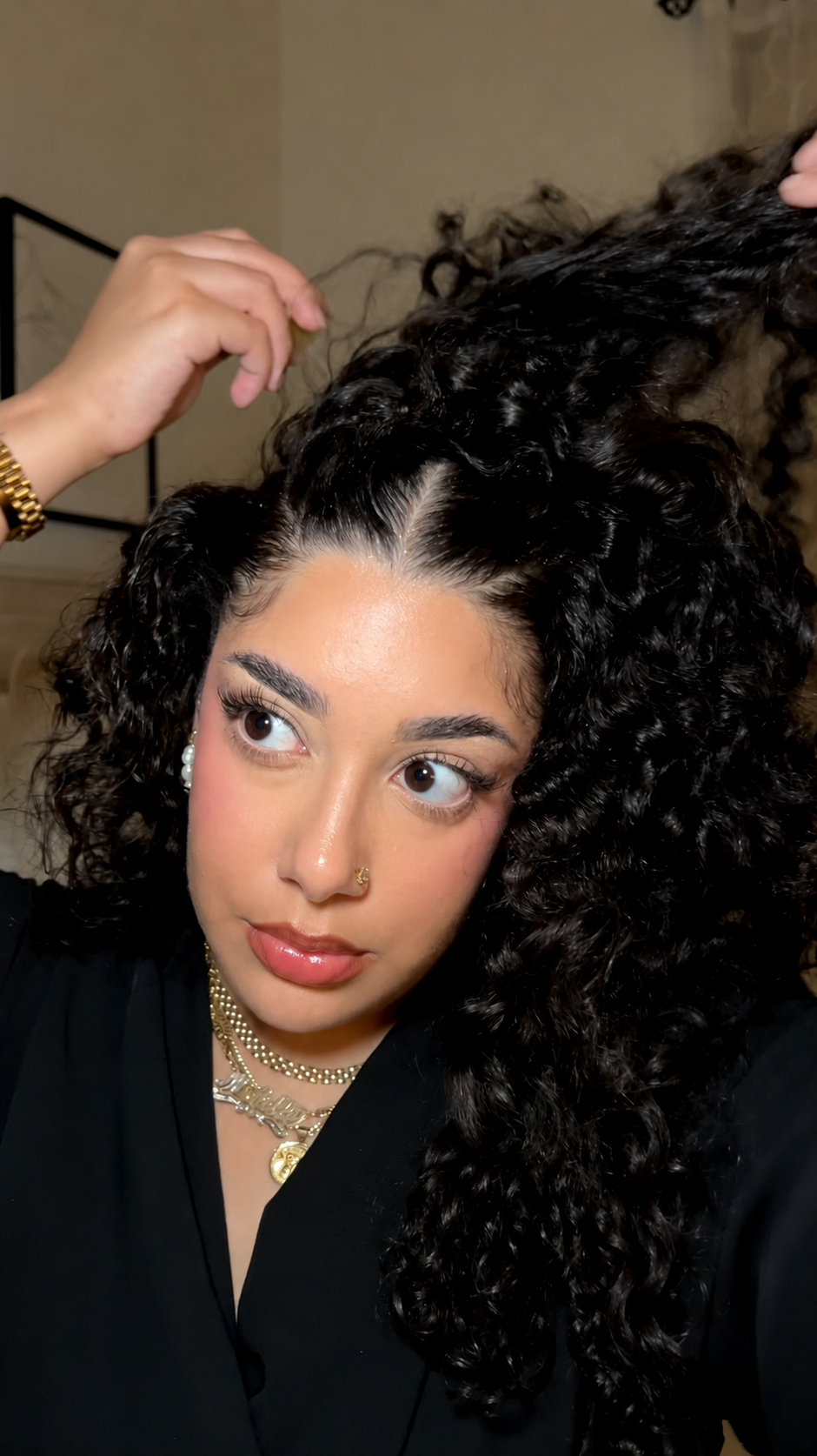 Woman with natural curls parting her hair during a scalp-care routine